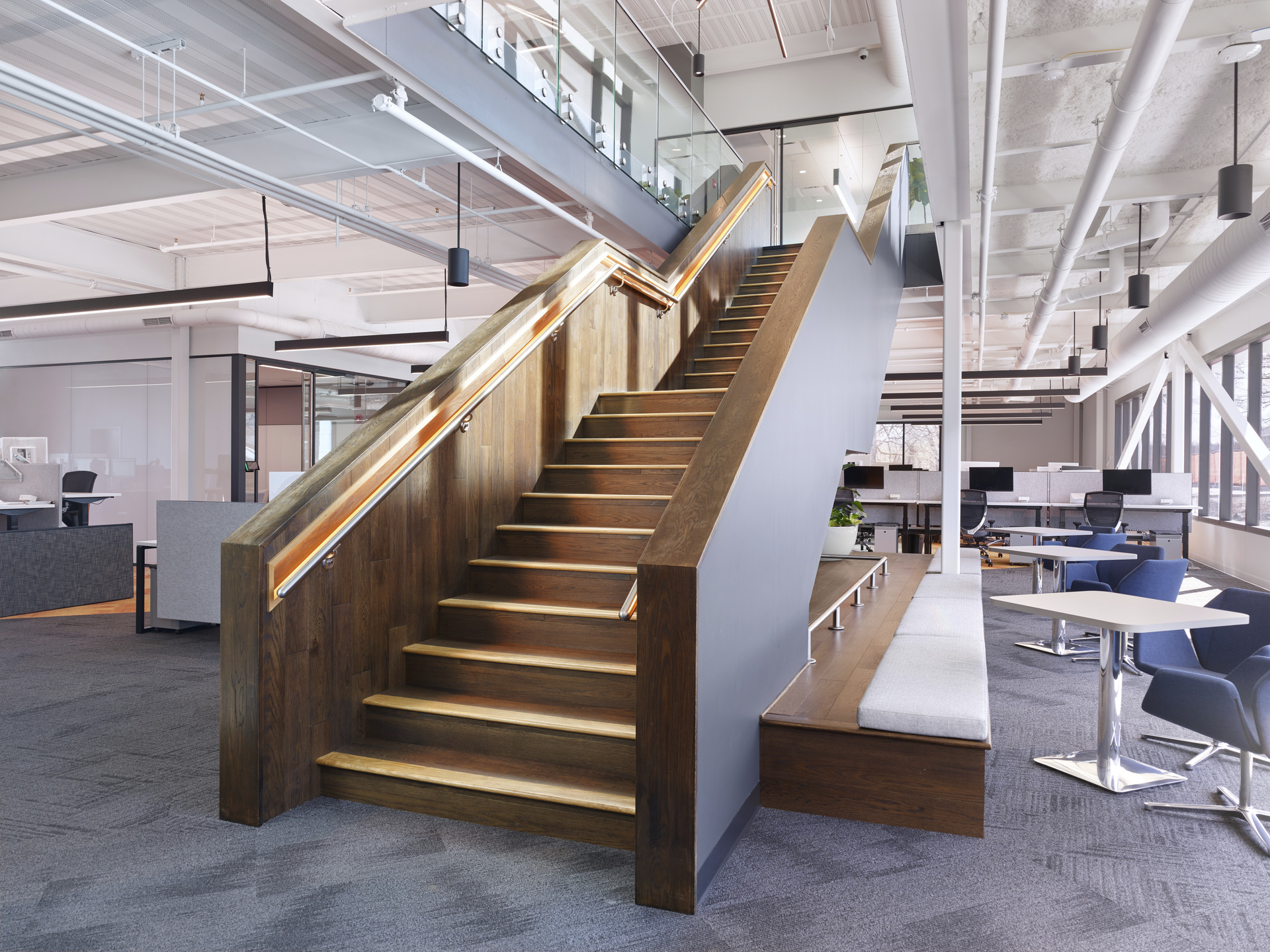 View of staircase with custom lit handrail and flexible work areas