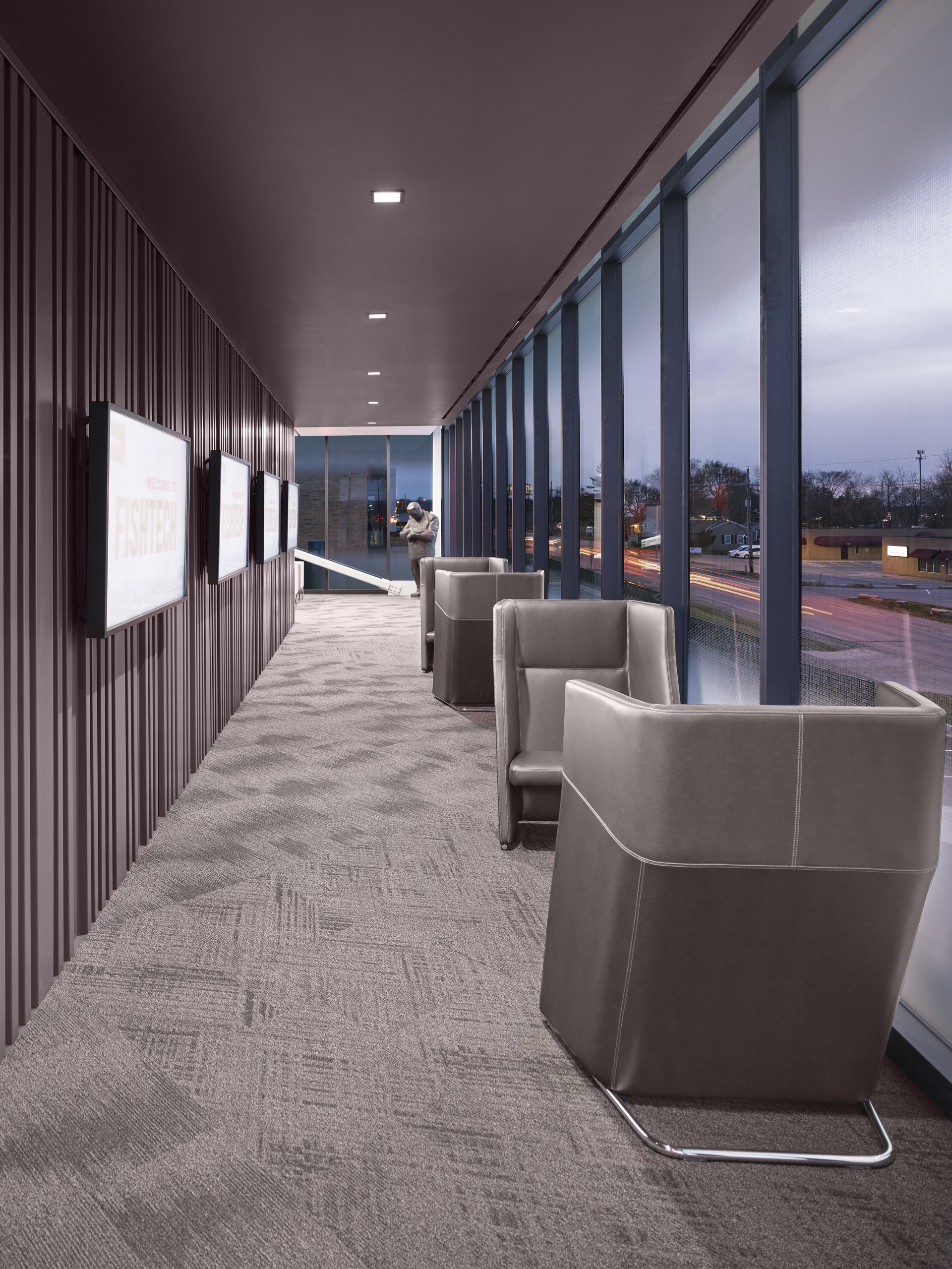 Hallway with textured wall, floor-to-ceiling windows, seating