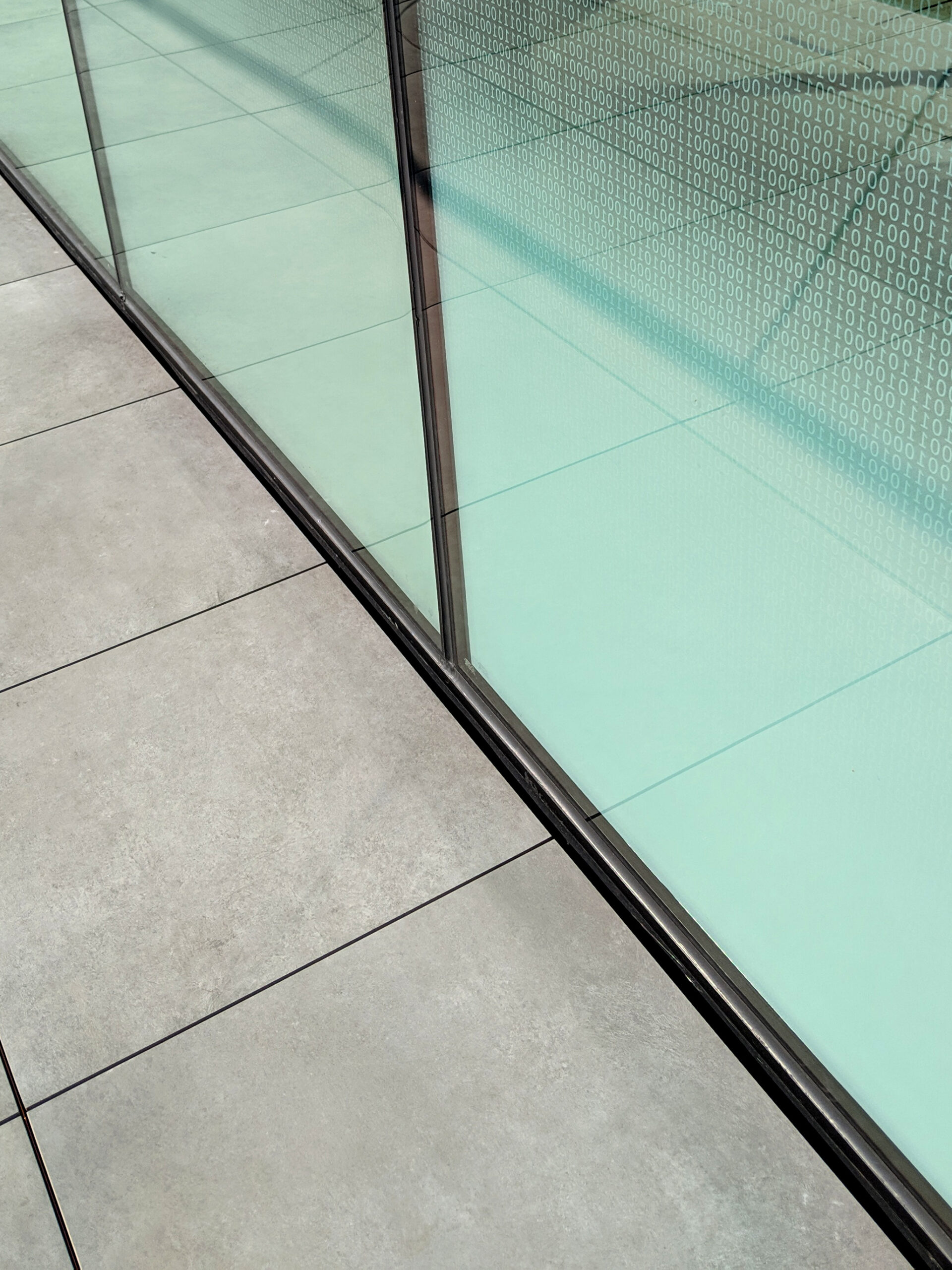 Custom fritted glass with binary code design detail along walkway
